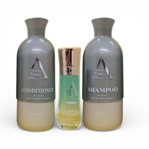 ثلاث عبوات من منتجات العناية بالشعر من Tonic تحتوي على شامبو، بلسم، وسيروم بالبروتين والكيراتين والكولاجين، موضوعة على سطح خشبي داكن.